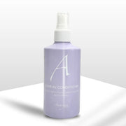 A purple bottle of Amargan Leave-In Conditioner with a white spray nozzle, labeled with the brand's logo.