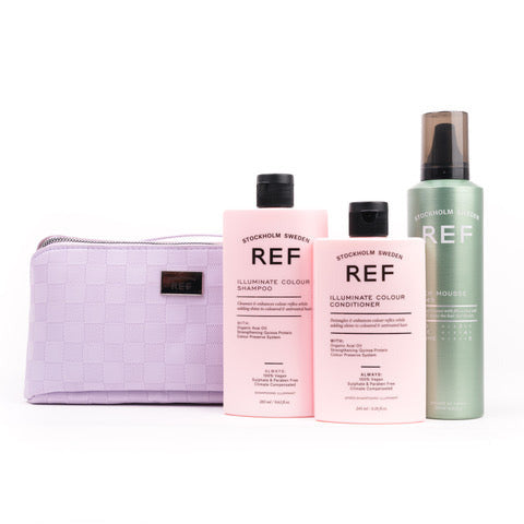 A set of Stockholm Review REF Illuminate Colour haircare products on a white background, including a lavender checkered pouch, a pink shampoo bottle, a pink conditioner bottle, and a mint green mousse bottle.