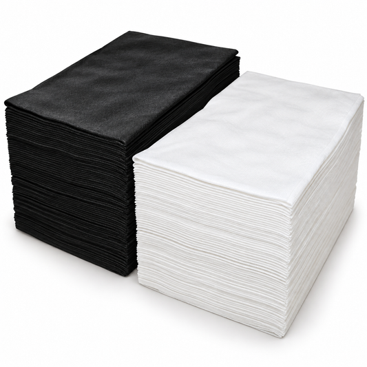 Two stacks of square fabric cloths, one black and one white, displayed side-by-side on a clean white background.