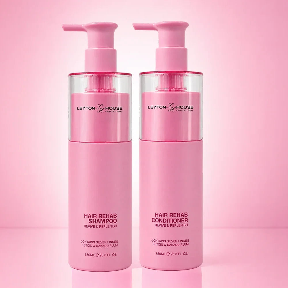Two pink pump bottles of Leyton House Hair Rehab shampoo and conditioner standing side by side on a pink gradient background.
