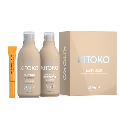 KITOKO Daily Luxe shampoo and conditioner bottles displayed next to their beige packaging box and an orange no. 4 nourishing lip oil tube on a clean white background.