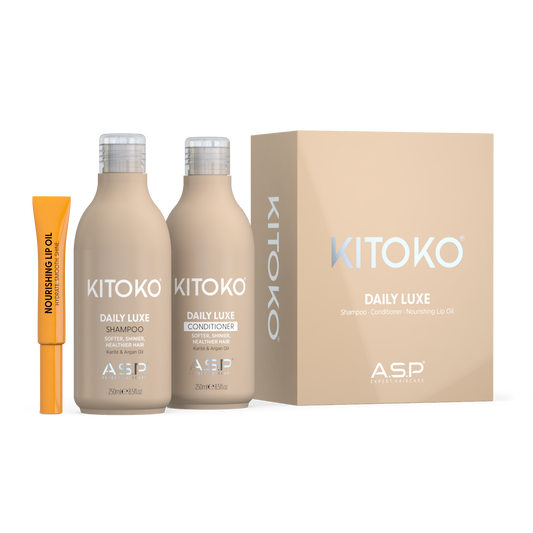 KITOKO Daily Luxe shampoo and conditioner bottles displayed next to their beige packaging box and an orange no. 4 nourishing lip oil tube on a clean white background.