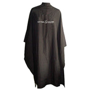 A professional black sleeveless cutting cape with the Leyton House logo printed on the back.