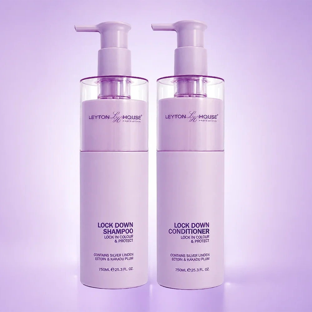 Two white plastic bottles of Leyton House Lock Down Shampoo and Lock Down Conditioner with pump dispensers, set against a soft lavender studio background.