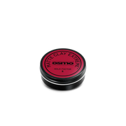 A round black tin of Osmo Matte Clay Extreme Hold Factor 8, featuring a vibrant red circular label, set against a solid white background.