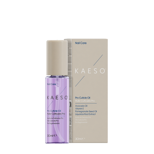 A bottle of KAESO Nail Care Pro Cuticle Oil next to its beige packaging box, featuring a lavender-colored liquid inside a clear bottle with a beige cap.