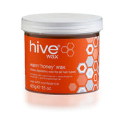 A container of Hive warm honey wax, weighing 425g, with an orange label featuring hexagonal patterns.