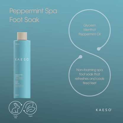 KAESO Peppermint Spa Foot Soak bottle in a light blue color with a beige cap, set against a matching teal-blue background with descriptive text and icons highlighting its ingredients and benefits.