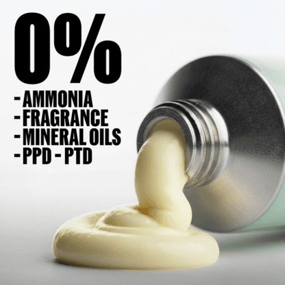 A close-up of a pale yellow cream or balm being squeezed from a silver tube onto a white surface, with large black text reading '0%' and a list of excluded ingredients: ammonia, fragrance, mineral oils, and PPD - PTD.