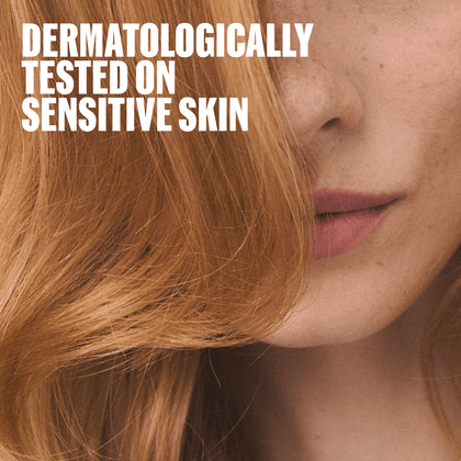 Close-up of a woman's lower face and hair with large white text reading 'DERMATOLOGICALLY TESTED ON SENSITIVE SKIN' over the top left.
