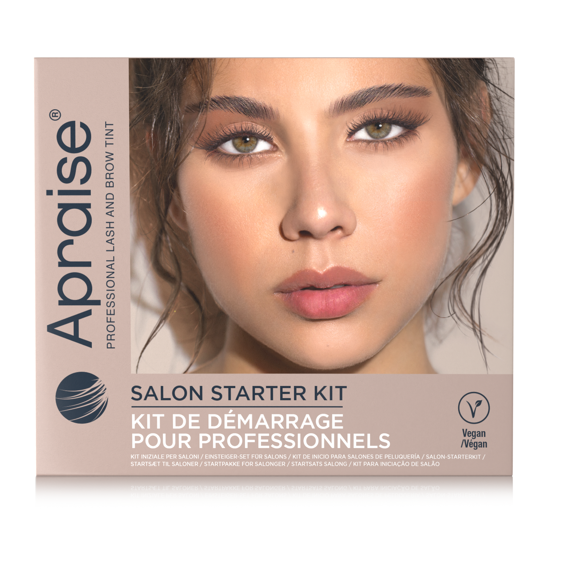 A rectangular box for the Apraise Salon Starter Kit, featuring a close-up photo of a woman's face with defined eyebrows and nude pink lips. The box is beige and white with black and blue text, and includes a 'Vegan' logo on the bottom right.