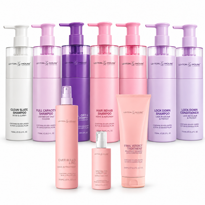 A collection of Layton House haircare products in various pump bottles and tubes, displayed against a solid white background. The set includes different colored versions of shampoo, conditioner, and treatment products in shades of white, pink, and purple.