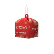 A red hanging box-shaped product package for KITOKO Oil Treatment, featuring gold snowflake patterns and a gold hanging loop, shown on a plain white background.