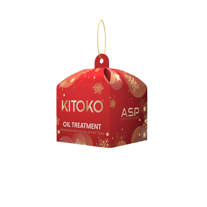 A red hanging box-shaped product package for KITOKO Oil Treatment, featuring gold snowflake patterns and a gold hanging loop, shown on a plain white background.