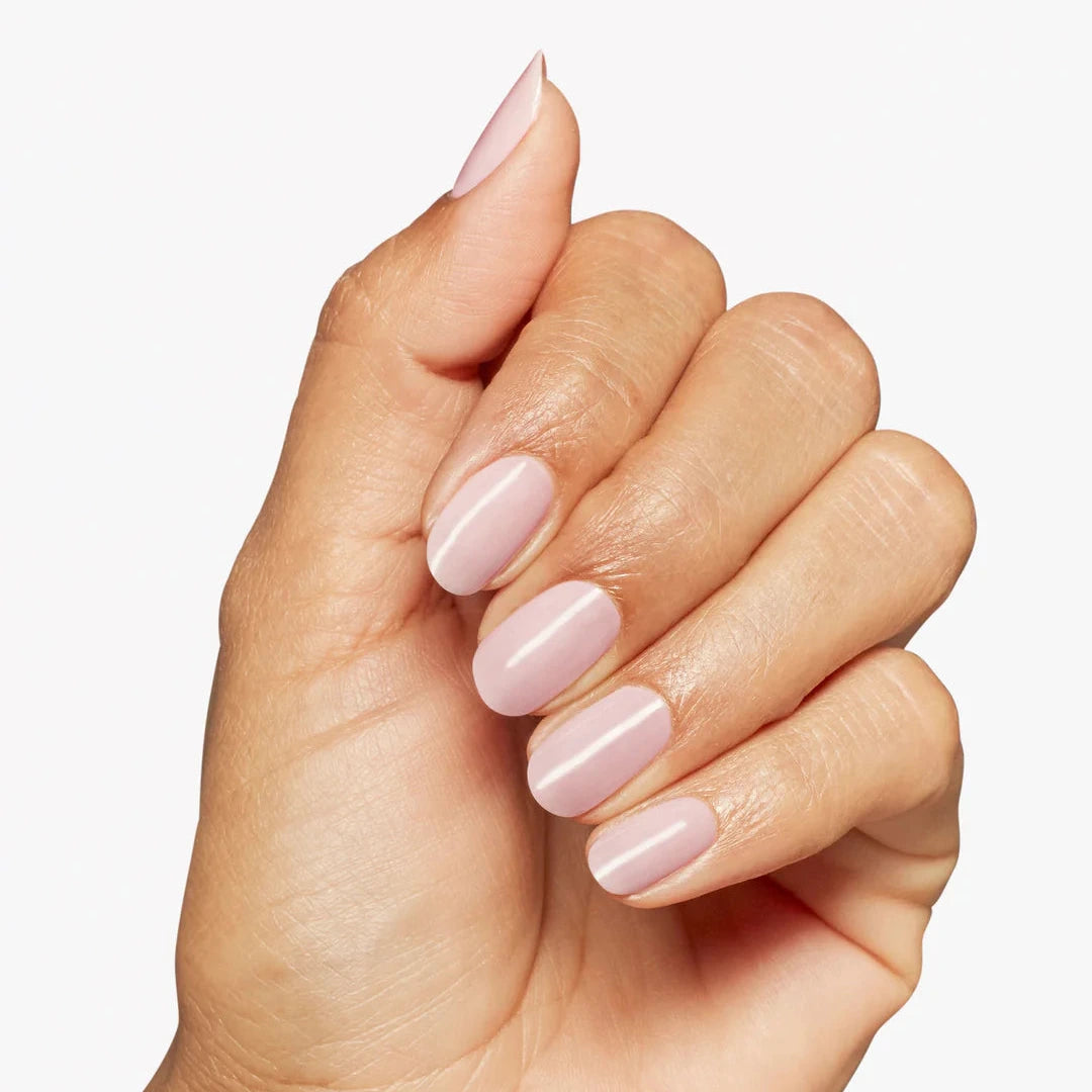 Hand with pink nail polish on a light background