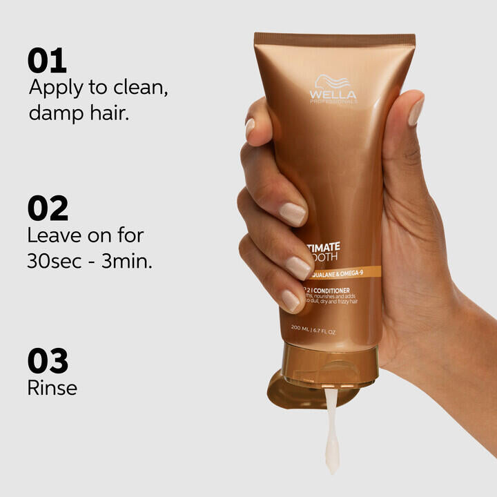 Hand holding a Wella conditioner bottle with application instructions on a light gray background