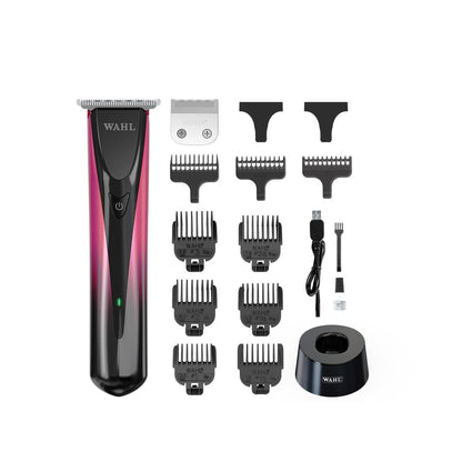 A Wahl cordless hair trimmer with a black and pink gradient body, shown with multiple black guide combs, a metal blade, a USB charging cable, a cleaning brush, and a black stand on a white background.