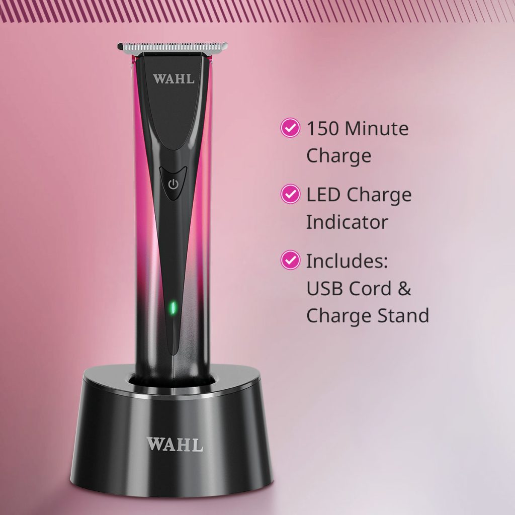A black Wahl cordless electric trimmer standing upright on a matching black charging stand against a pink gradient background. Text on the right lists features: 150 minute charge, LED charge indicator, and includes USB cord & charge stand.