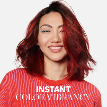 Woman with red hair and a red sweater, with 'Instant Color Vibrancy' text. wella color brilliance